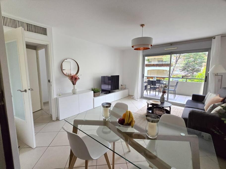 un salon avec une table en verre et des chaises dans l'établissement 45m2 Luxueux 2P hypercentre terrasse Parking, à Cannes