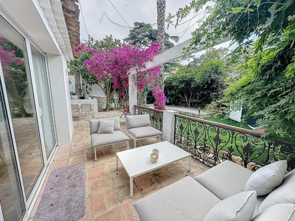 d'une terrasse avec un canapé, des chaises et une table. dans l'établissement 55m2 Charmante maison mitoyenne, jardin, parking, à Cannes