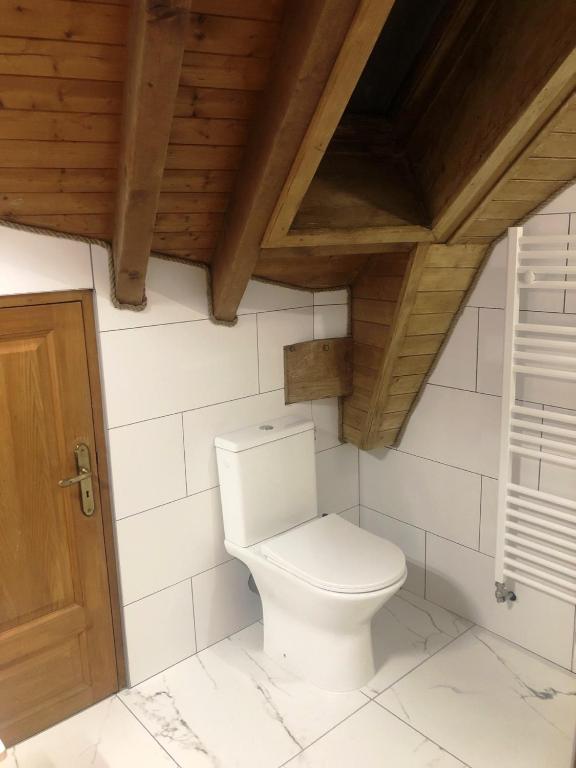 a white toilet in a bathroom with a wooden ceiling at Chalet Leslie in Morzine
