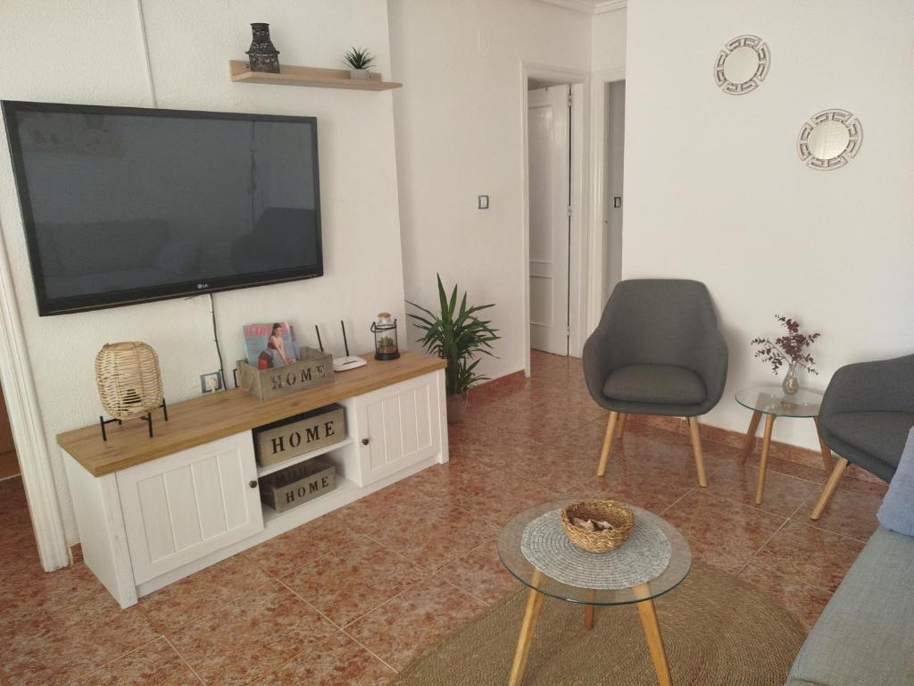 een woonkamer met een flatscreen-tv aan de muur bij Dreams Holidays in Gran Alacant