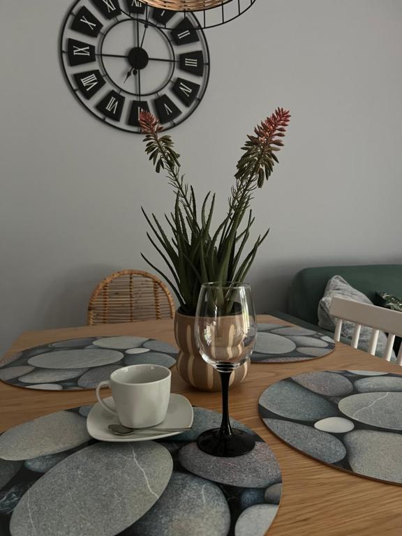 a table with a glass of wine and a clock at Boya Home in Wilkasy