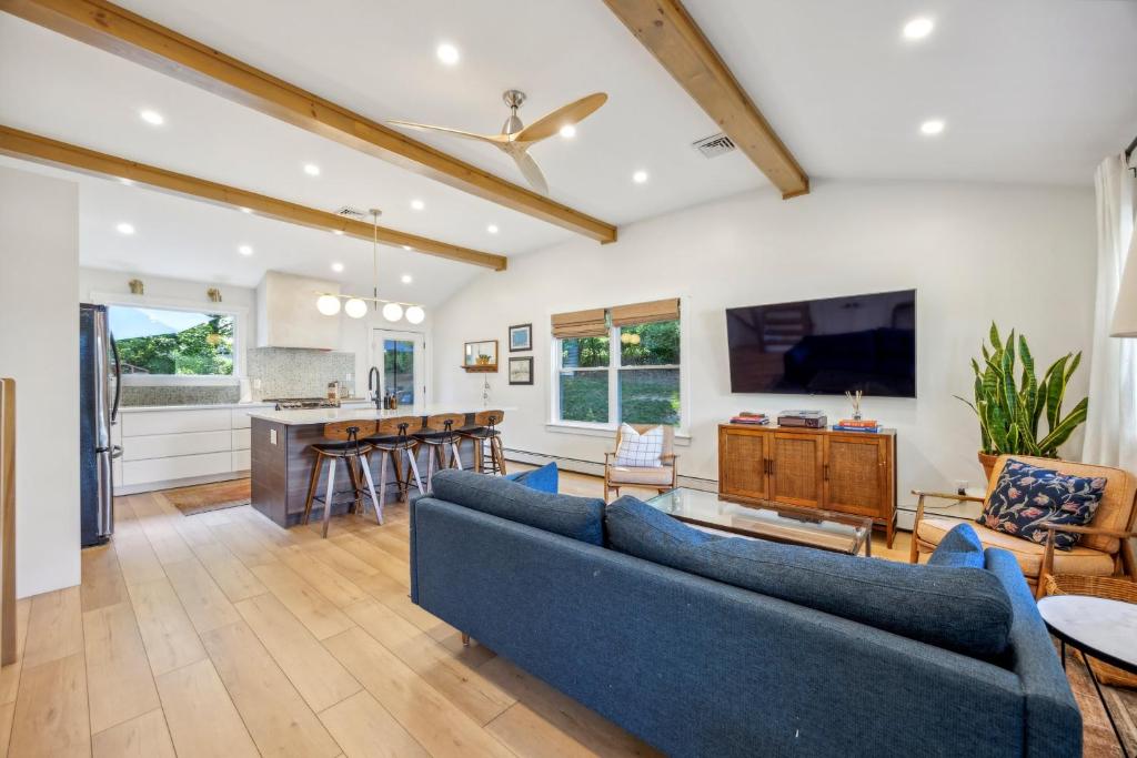a living room with blue couches and a kitchen at Modern Mid-Century Retreat in West Chester