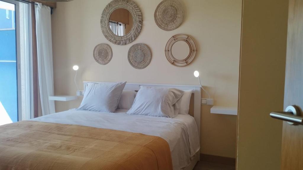 a bedroom with a bed and mirrors on the wall at Apartamento con vistas al mar B4 Urb Puerto Azul in Cedeira