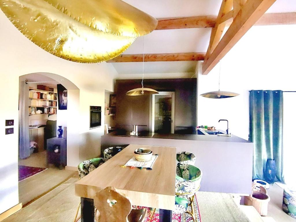 a kitchen with a wooden table in a room at Là où le Ciel est né Beau mas pierres et contemporain sur grande propriété vue Mont Ventoux dentelles de Montmirail in Blauvac