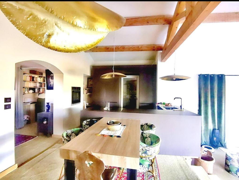 a kitchen with a wooden table in a room at Là où le Ciel est né Beau mas pierres et contemporain sur grande propriété vue Mont Ventoux dentelles de Montmirail in Blauvac