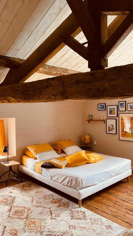 une chambre avec un grand lit dans un grenier dans l'établissement Au bon endroit, à Sevremont