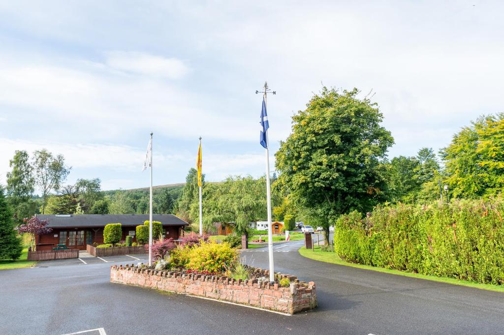 a parking lot with flags and a building at Lomond Woods Holiday Park in Balloch