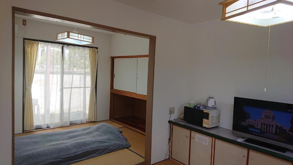 a living room with a tv and a window at Lilac Hotels and Resorts - Vacation STAY 39764v in Kanoya
