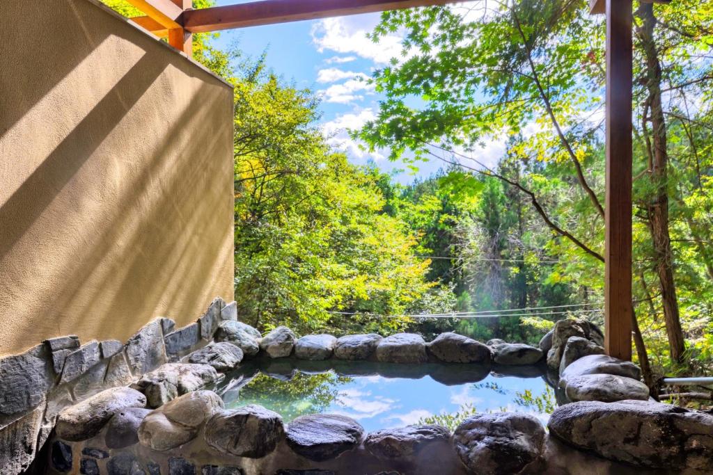 a pool of water in a stone wall with a waterfall at Pension Yumi - Vacation STAY 20865v in Nikko