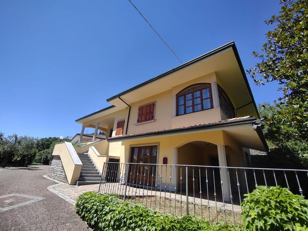 a large yellow house with stairs in front of it at Villa Nonna Elisa in Pieve