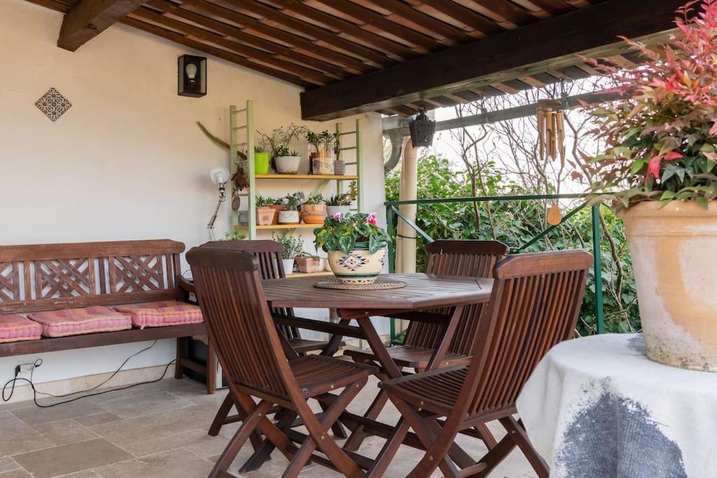 une table et des chaises en bois sur une terrasse dans l'établissement Maison Aix-en-Provence, à Aix-en-Provence