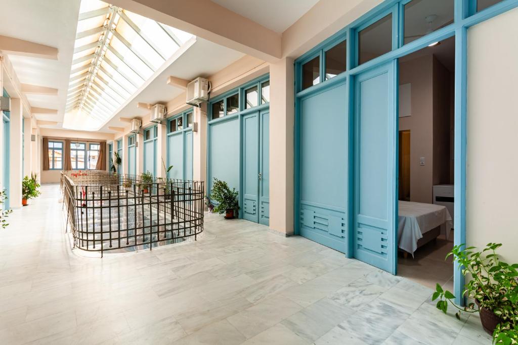 a hallway with blue doors and a bed in a room at Στούντιο Στη Στοά Βαρβουτσή#9 in Kalamata