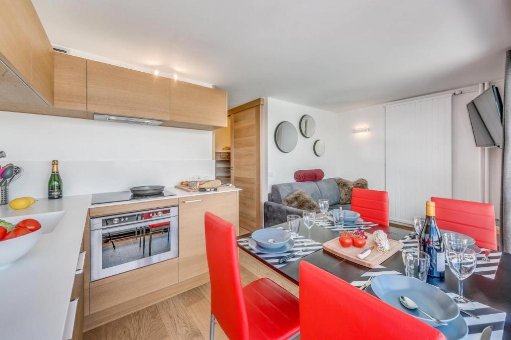une cuisine et une salle à manger avec une table et des chaises rouges dans l'établissement Résidence Palafour - Studio cabine 4 personnes pieds des pistes - balcon vue Grande Sassière MAE-3629, à Tignes