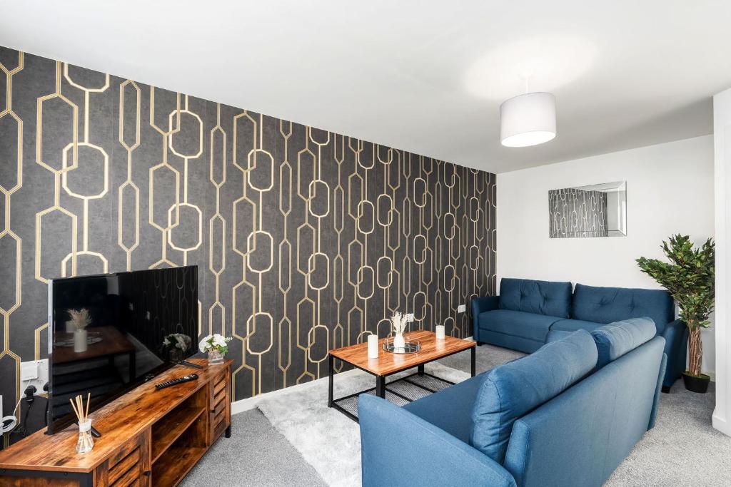 a living room with a blue couch and a tv at Eagle Drive - Humberston in Humberston
