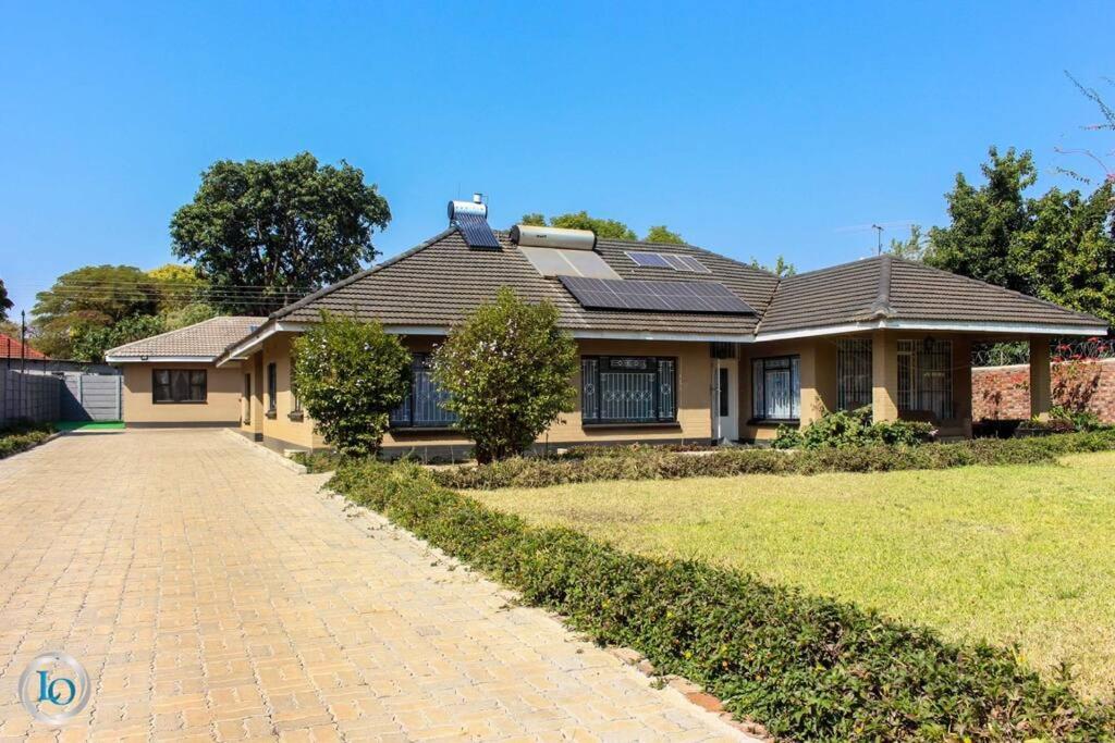 a house with a brick driveway in front of it at Little Oasis Self Catering Cottage in Harare