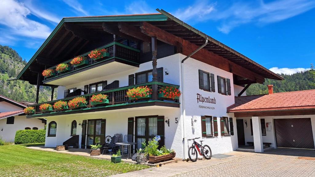 a white building with flower boxes on the balcony at Ferienwohnung Fleck in Reit im Winkl