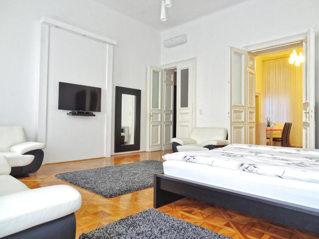 a white room with a bed and a tv at Erzsebet Boulevard Apartment in Budapest