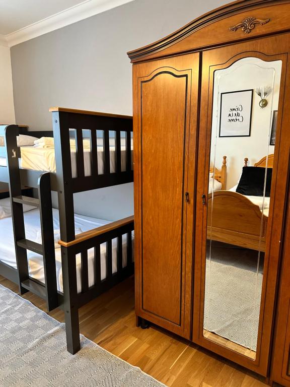 a bedroom with a wooden cabinet and a bunk bed at Malahide Guest Rooms in Malahide