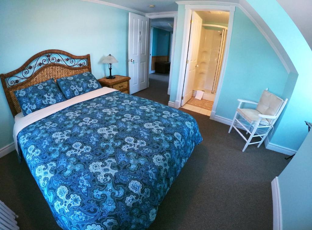 a bedroom with a bed with a blue comforter at Chez Caro et Sylvain in Rimouski