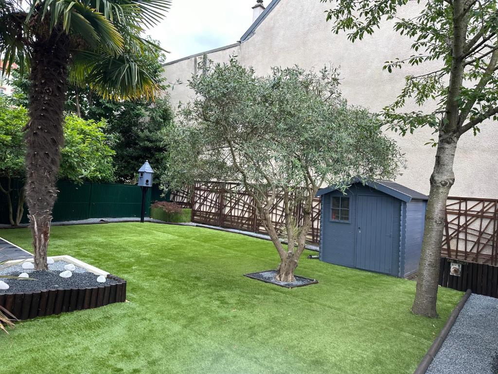 un jardin avec deux arbres et un abri bleu dans l'établissement Maison parisienne, à La Garenne-Colombes