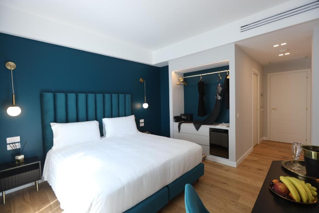ein Schlafzimmer mit einem weißen Bett und einer blauen Wand in der Unterkunft Regola Luxury Relais in Rom