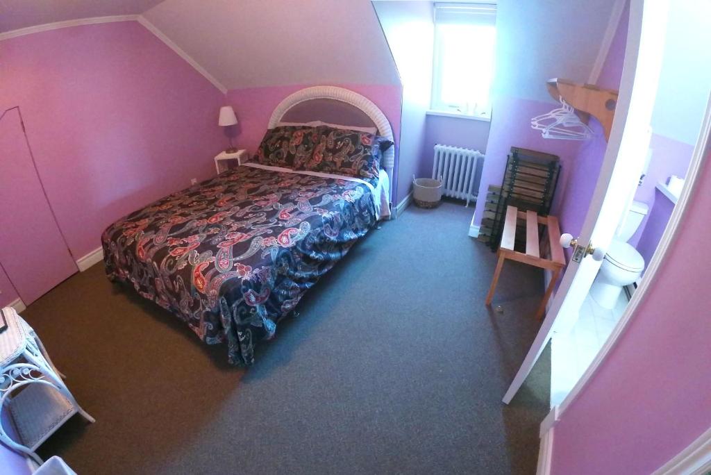 a bedroom with a bed in a pink room at Chez Caro et Sylvain in Rimouski
