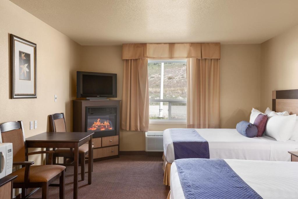 Postel nebo postele na pokoji v ubytování Grande Cache Inn & Suites