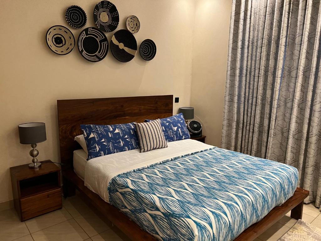 a bedroom with a bed with plates on the wall at The Fancy convenience-free wifi Kyanja in Kampala