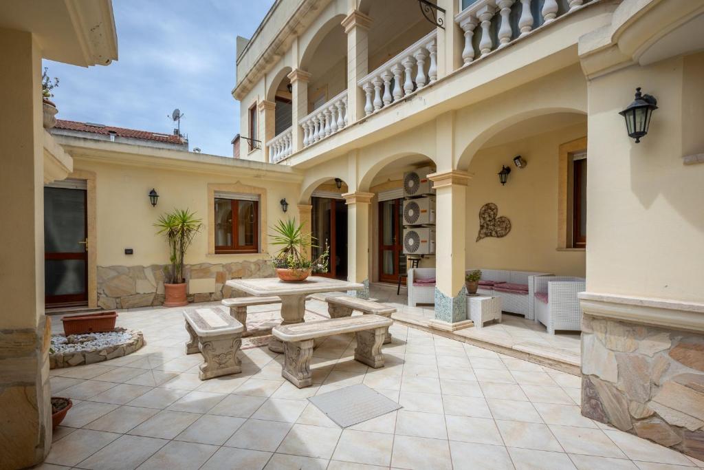 un patio esterno con panchine e un edificio di La Casa di Tonina a Quartu SantʼElena