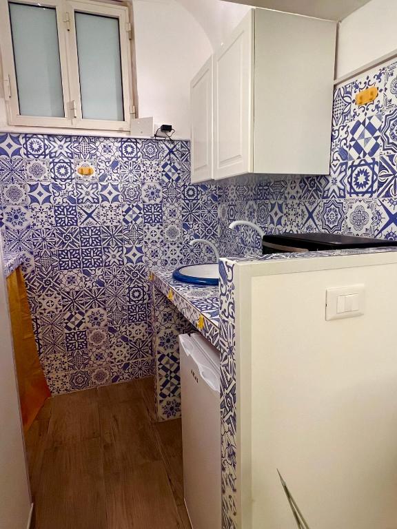 卡塔尼亚Sweet Home Catania historic center的厨房的墙壁上铺有蓝色和白色的瓷砖。
