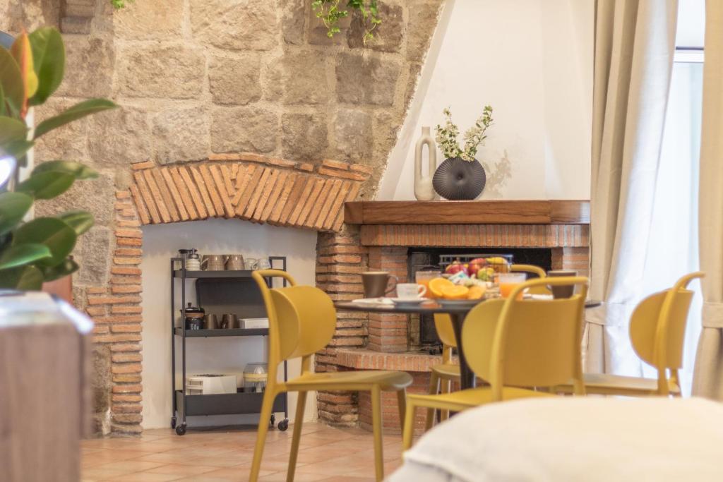 a living room with a table and chairs and a fireplace at A casa di Fedora in Viterbo