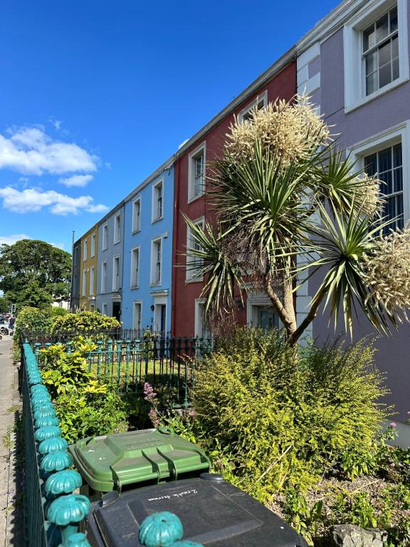 a row of green benches in front of a building at Malahide Guest Rooms in Malahide