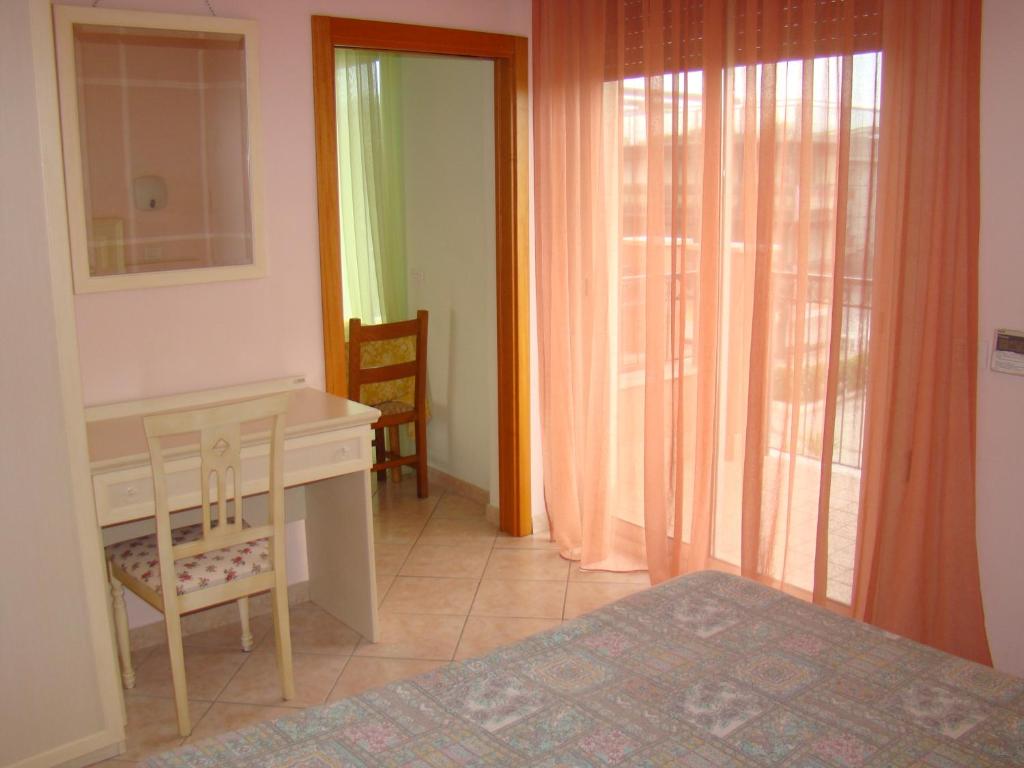 a bedroom with a bed and a desk and a window at Il Casale in Martinsicuro