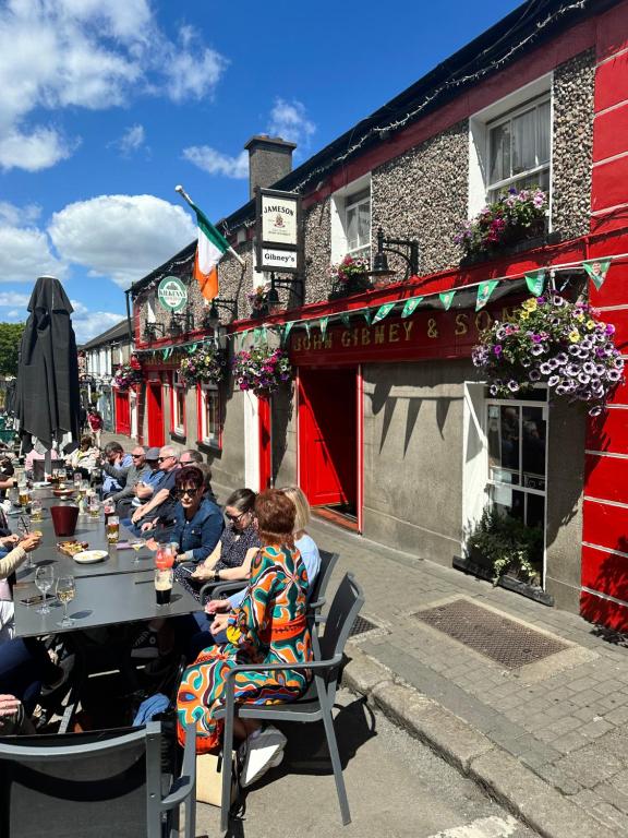 a group of people sitting at a table outside a restaurant at Malahide Guest Rooms in Malahide