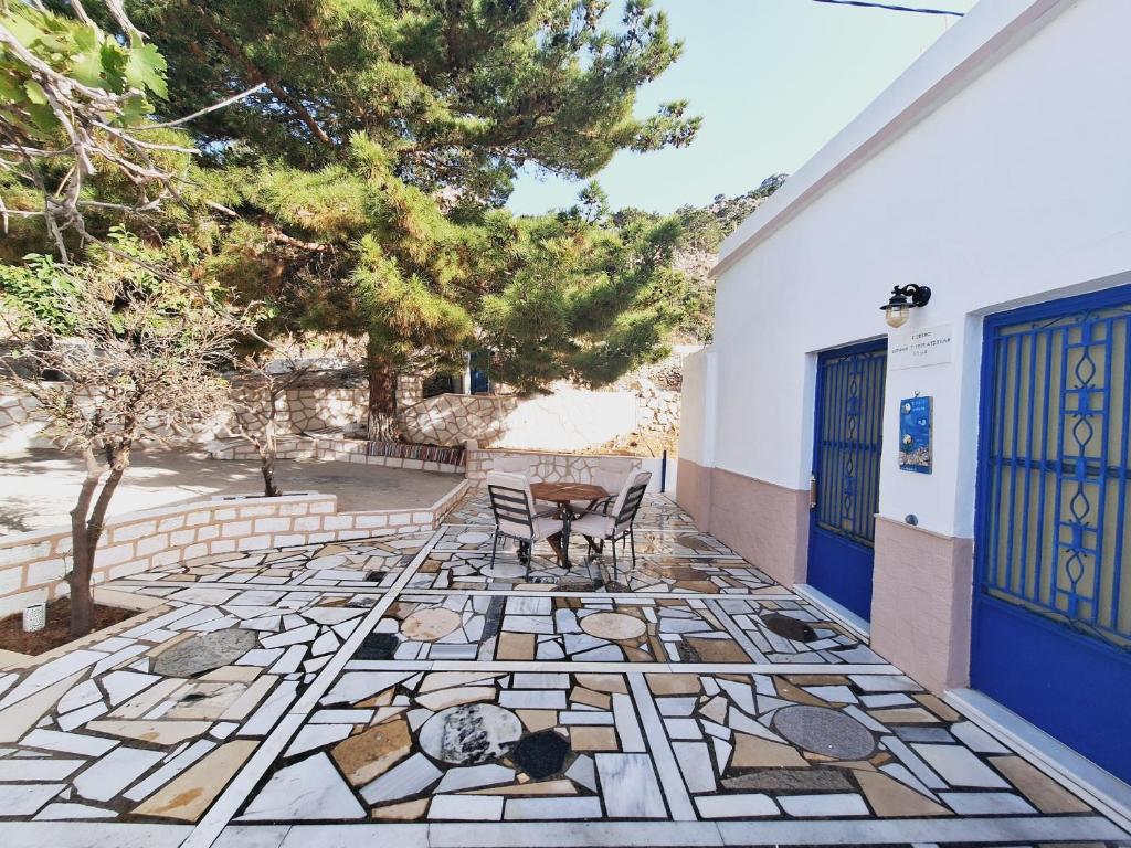 a patio with a table and chairs and a tree at Zoes House in Kyra Panagia