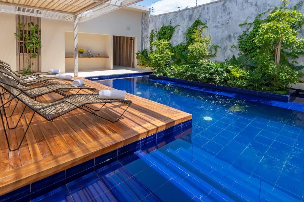 a pool with a deck and a chair next to it at Nueva Apartasuite pleno centro in Santa Marta