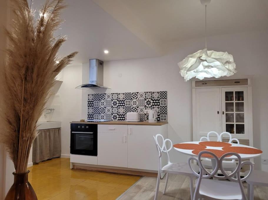 une cuisine avec une table et des chaises dans une cuisine dans l'établissement Petite maison entre mer et montagne, à Céret