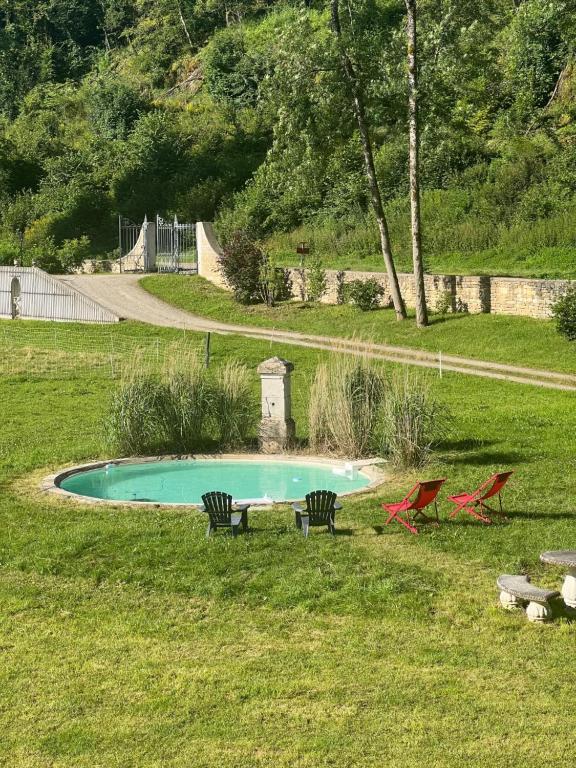 a pool with two chairs and a table in a yard at Abbaye de l'Etanche - Un cadre naturel exceptionnel - Patrimoine - in Rollainville