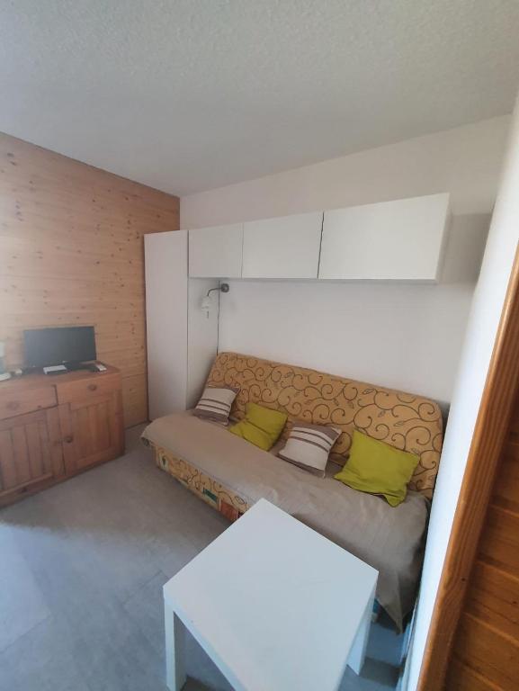 - une petite chambre avec un lit et des oreillers verts dans l'établissement Appart Alpe d Huez, à L'Alpe-d'Huez
