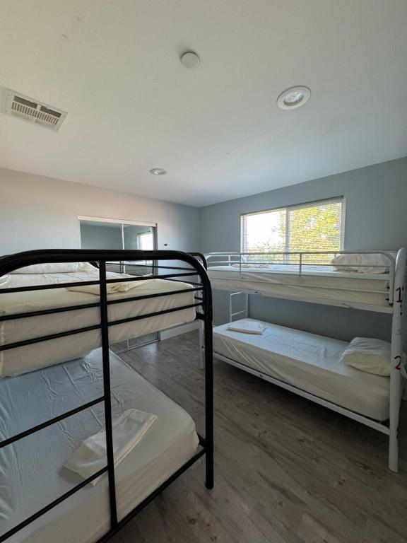 una habitación con tres literas y una ventana en California Castle - Fashion District - DTLA - Flexible, en Los Ángeles