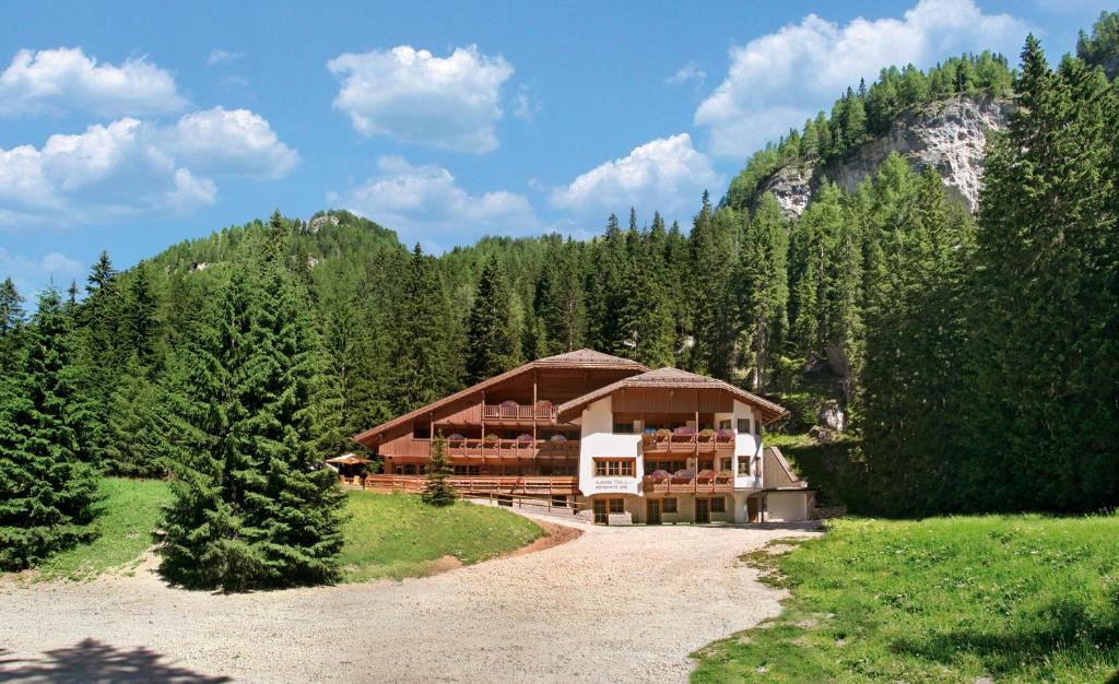 a large building in the middle of a forest at Hotel Villetta Maria Cottage in Canazei