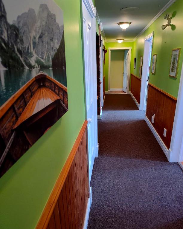 a hallway with green walls and a boat on the wall at Chez Caro et Sylvain in Rimouski