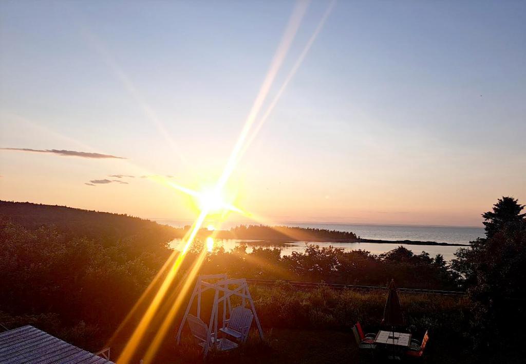 a sunset with the sun setting over the water at Chez Caro et Sylvain in Rimouski