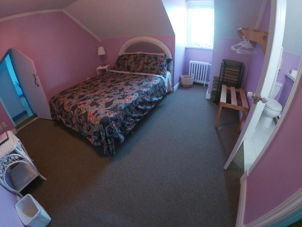 a bedroom with a bed in a pink room at Chez Caro et Sylvain in Rimouski
