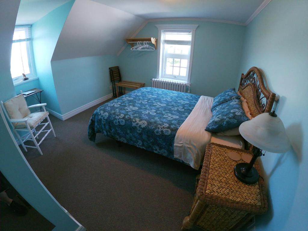 a bedroom with a bed and a lamp and a chair at Chez Caro et Sylvain in Rimouski