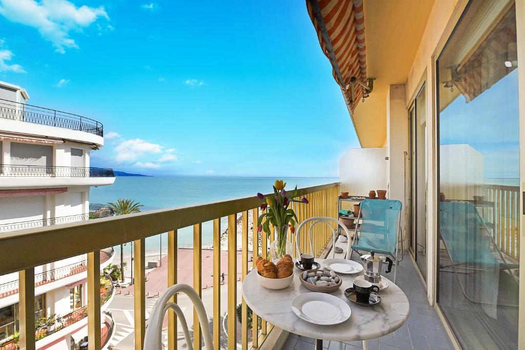 un balcon avec une table et des chaises et l'océan dans l'établissement Residence Cap 35 - Happy Rentals, à Roquebrune-Cap-Martin