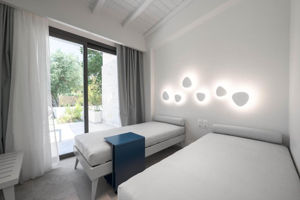 a bedroom with two beds and a window at Astrum Luxury Suites in Vourvourou