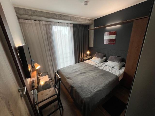 ein kleines Schlafzimmer mit einem Bett und einem Fenster in der Unterkunft MECHELinn in Mechelinki