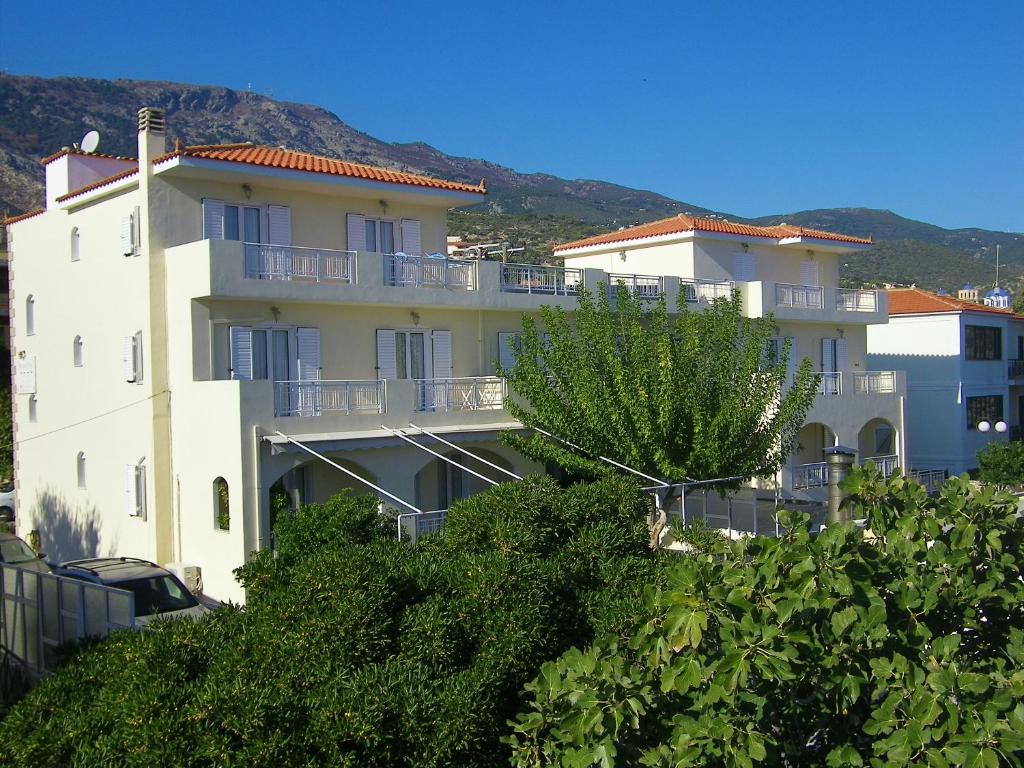 un gran edificio blanco con árboles delante de él en Hotel Filioppi, en Agios Kirykos