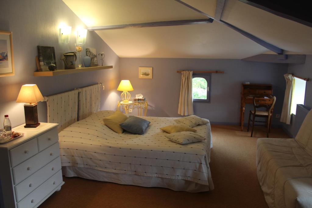 ein Schlafzimmer mit einem Bett mit zwei Kissen darauf in der Unterkunft Au Bon Accueil in Jonzac